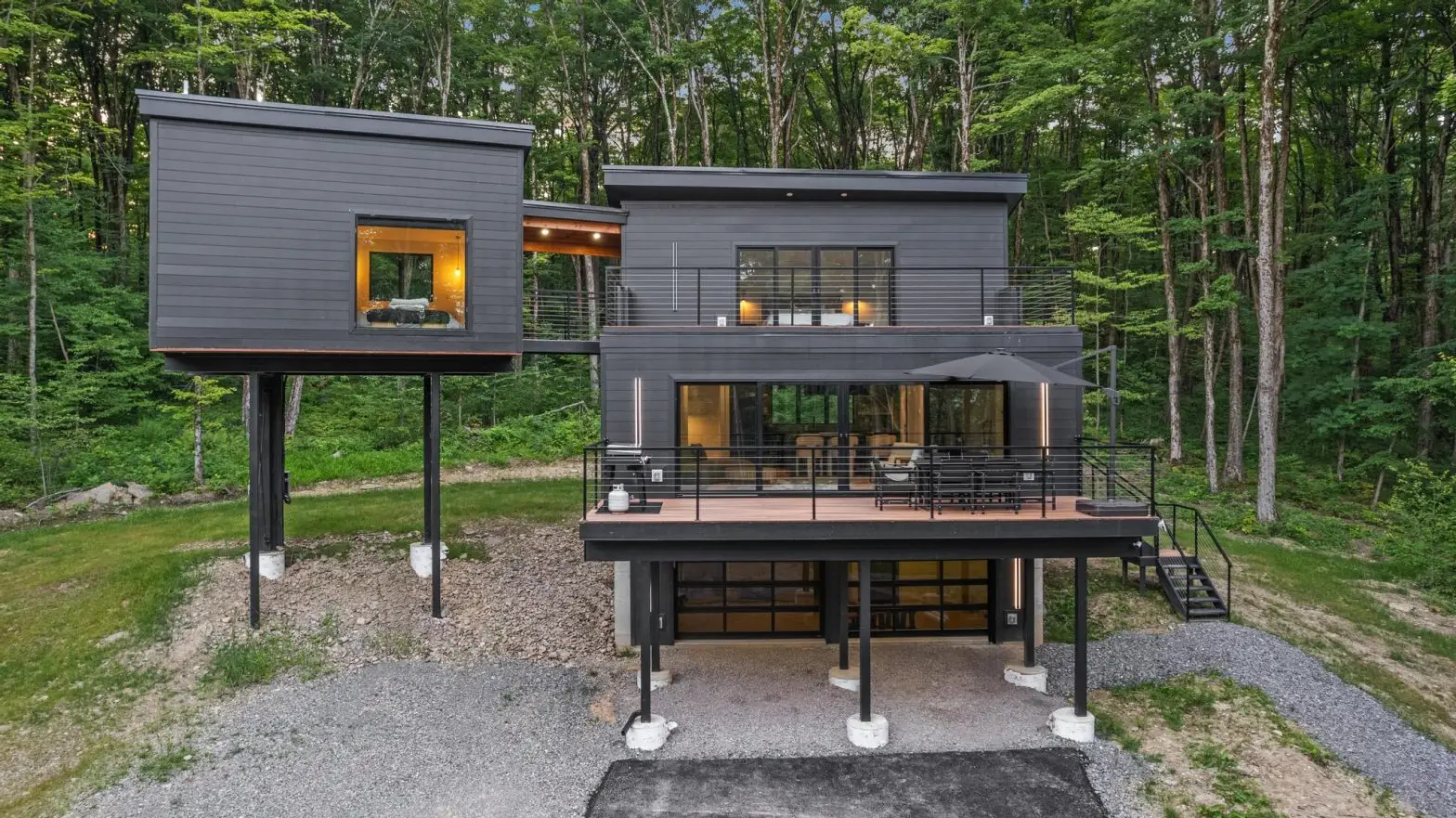 Modern Airbnb property in Ellicottville, NY, featuring sleek architecture, large windows, and a forested backdrop, ideal for attracting bookings.